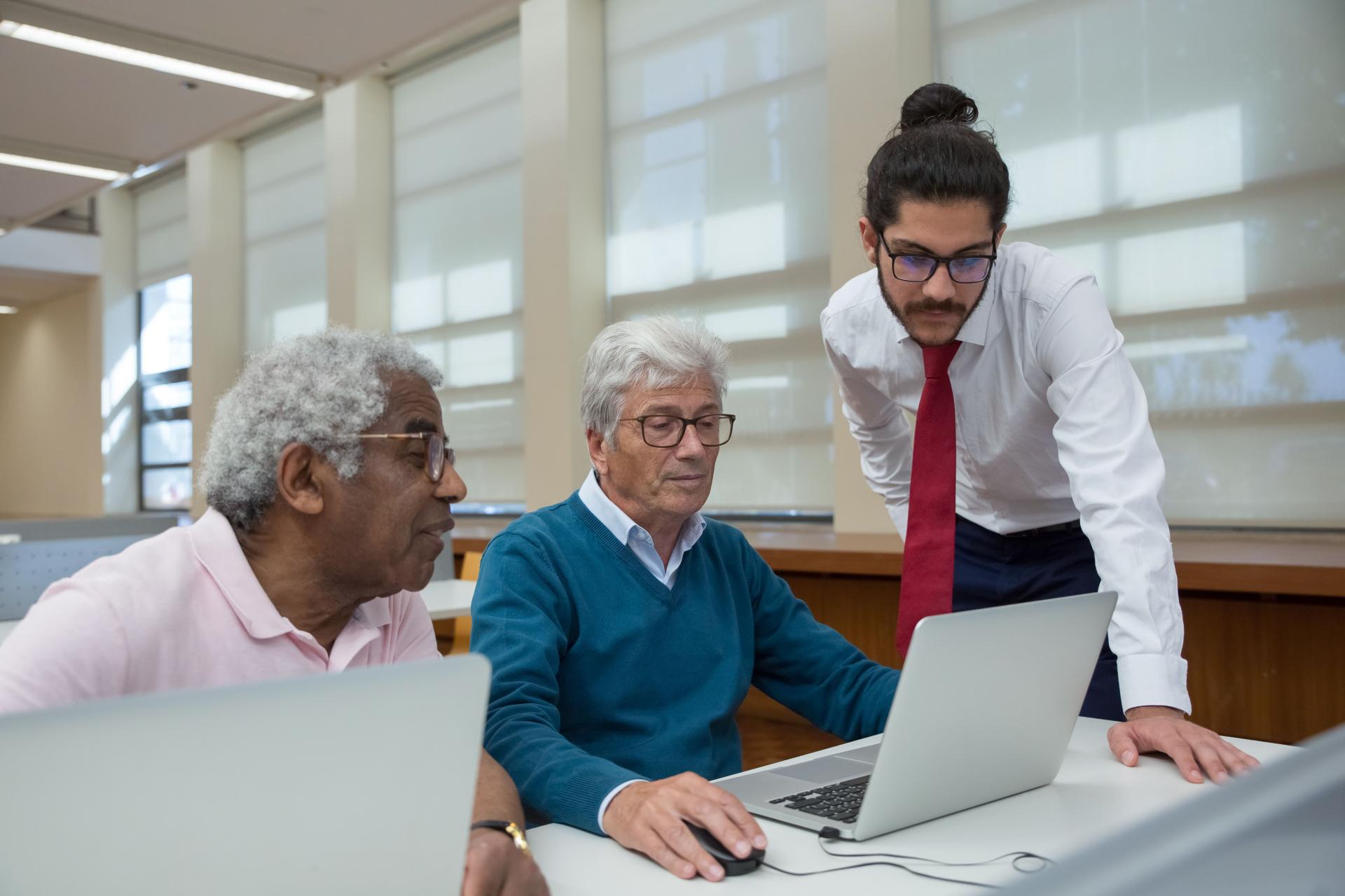 Drie medewerkers bekijken de resultaten op een laptop
